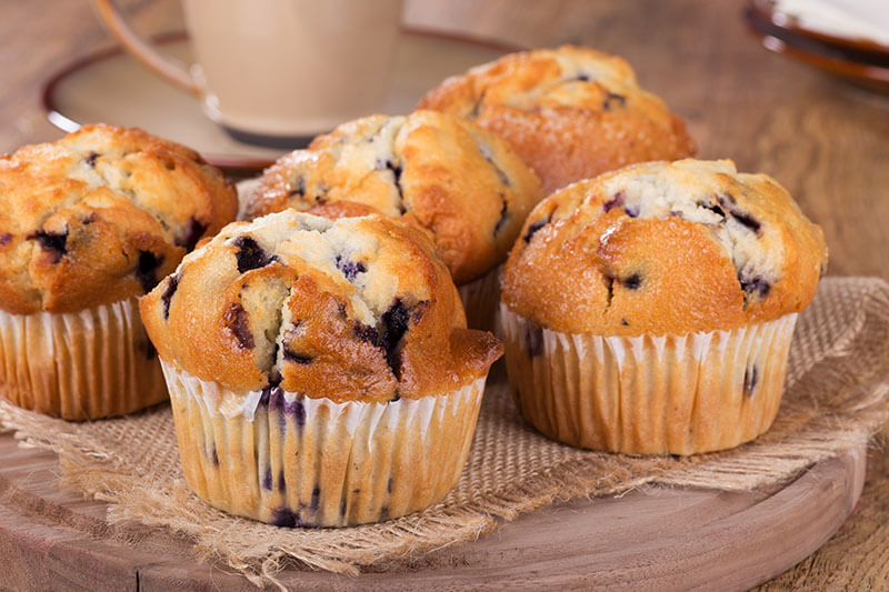 Group of blueberry muffins on a wooden platter