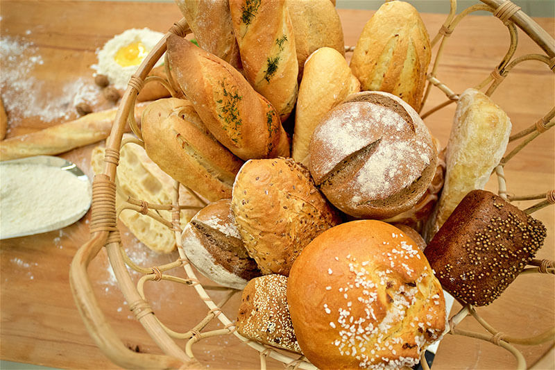 Concept shot of many mixed breads and baguette in the basket, above perspective.